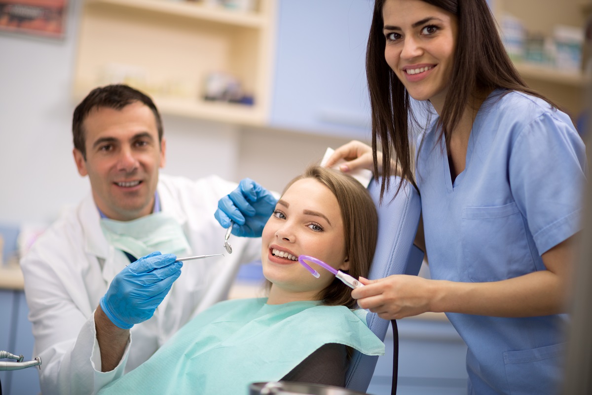 patient with dentist and assistant