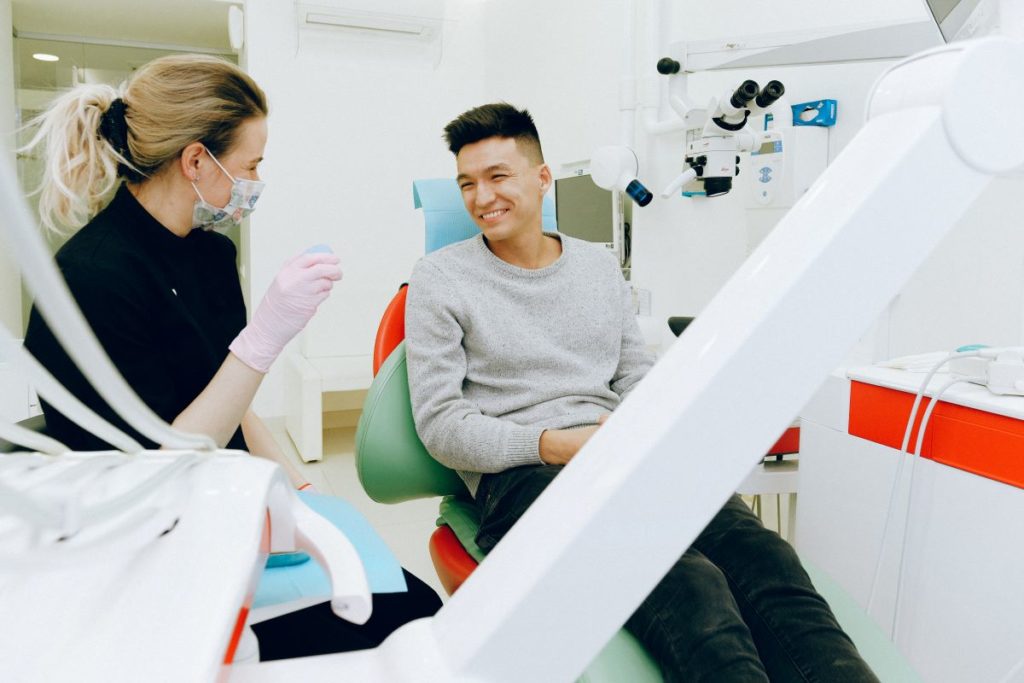 man sitting on dentist chair smiling