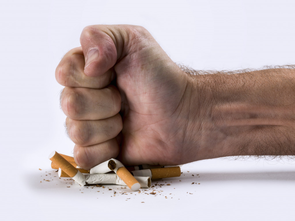 A fist crushing some cigarettes
