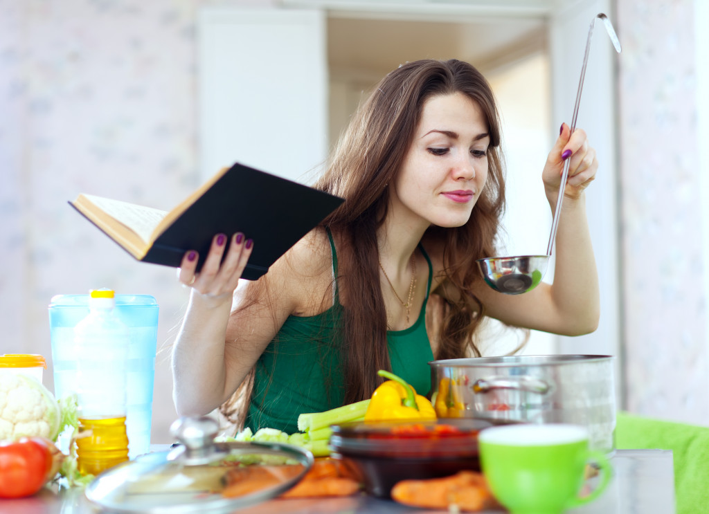 A woman cooking with a cookbook