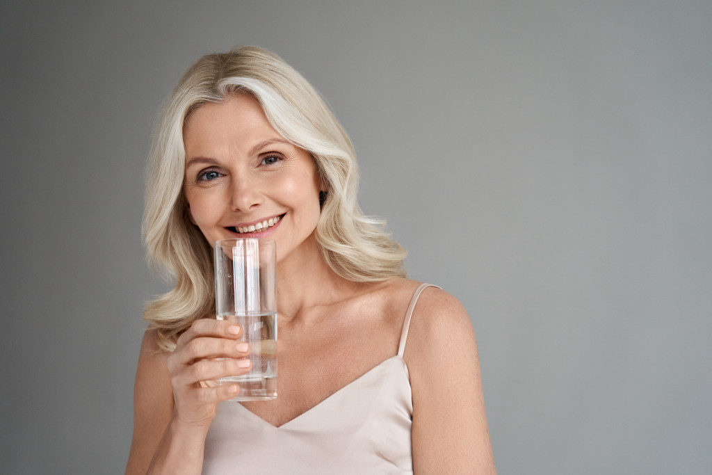 A mature woman holding a glass of water