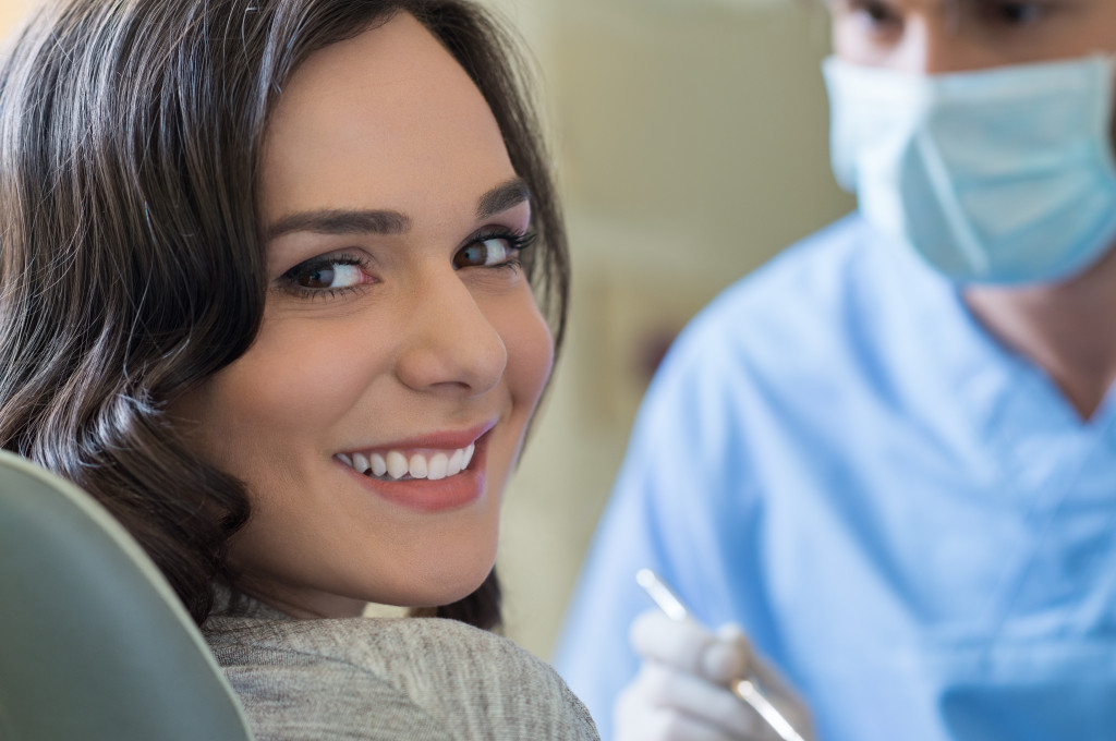 smiling woman looking back with dentist at the front