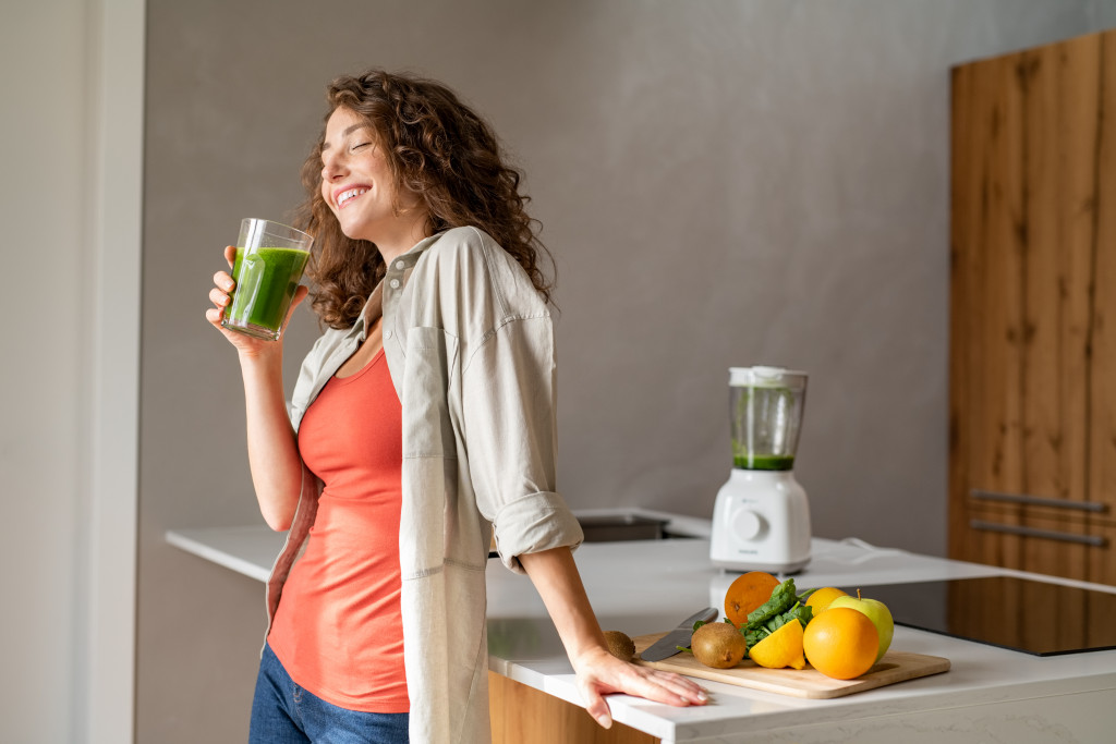 healthy woman drinking green smoothie