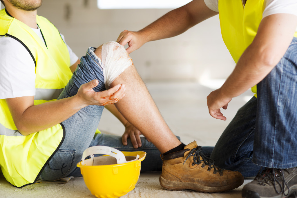 a first responder applying bandages to a construction worker